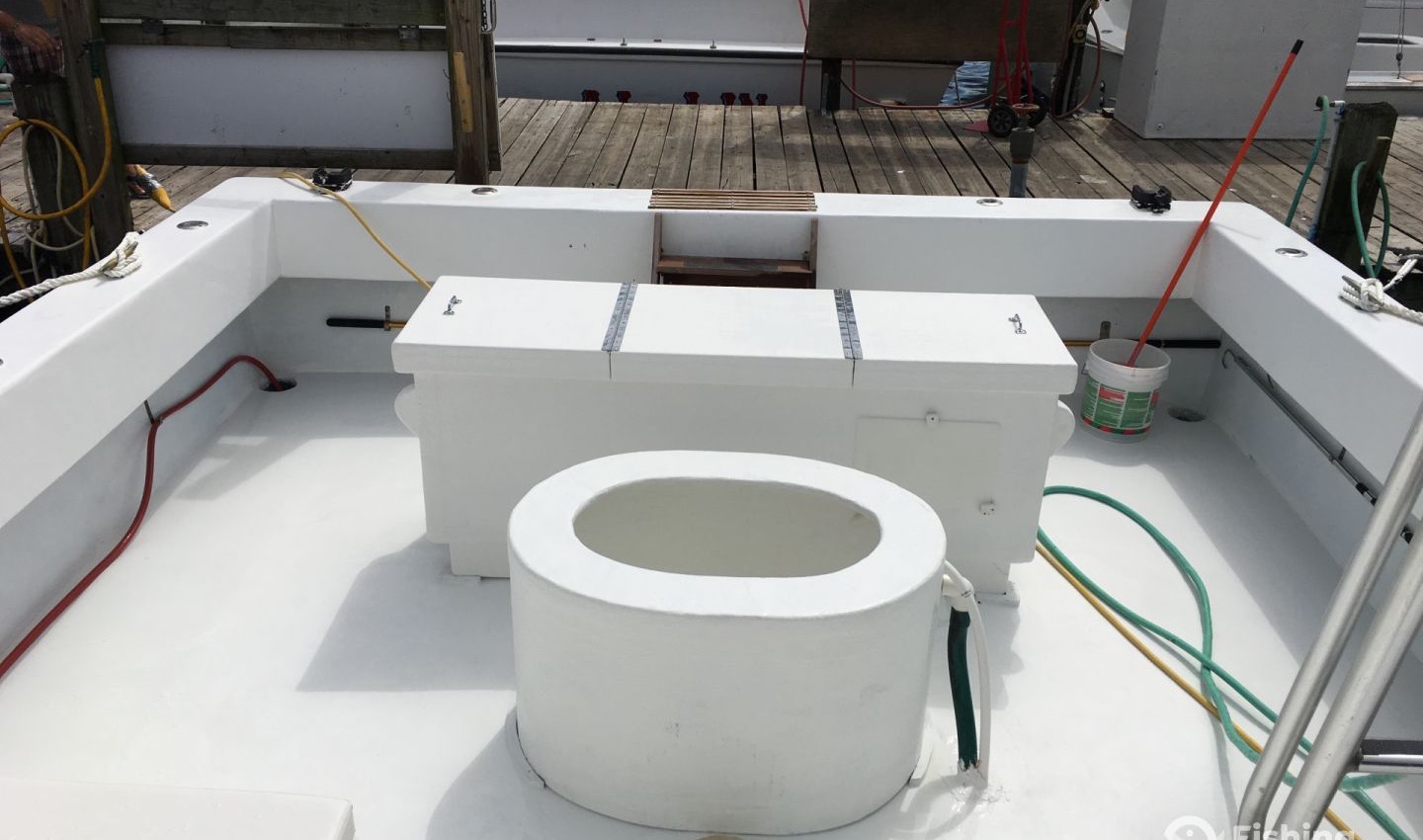 The wide-open white cockpit deck with centered live well, big fish box, and walk-around room